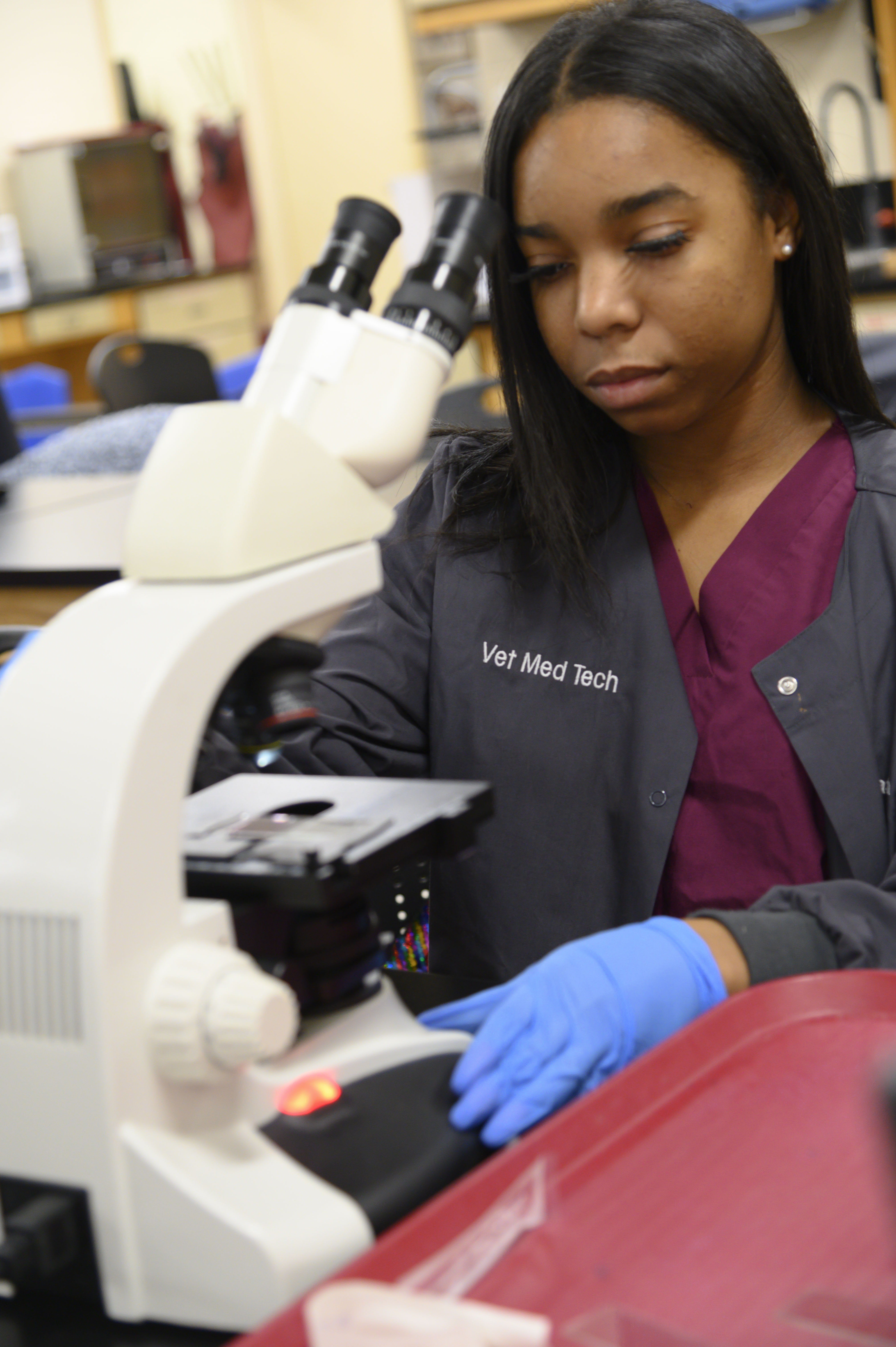 A student adjusts her microscope