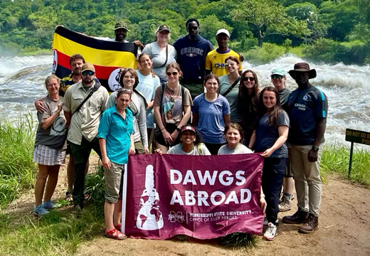 A group of CVM students in Uganda holding a MSU sign.